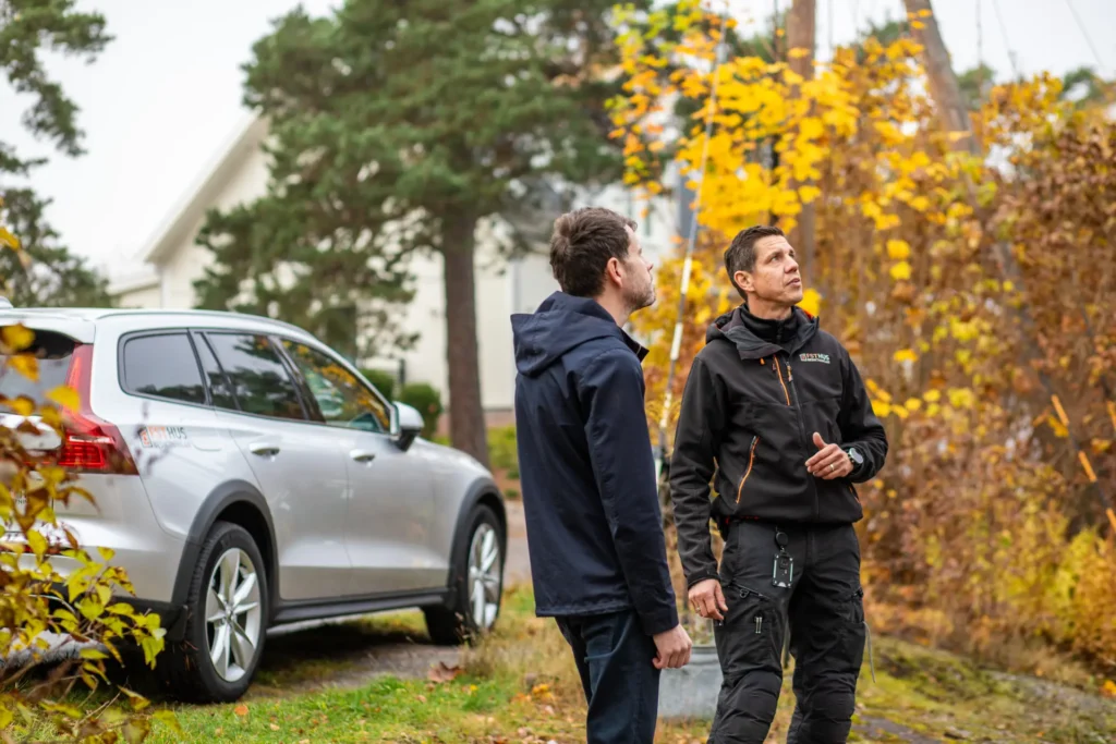 Besiktningsman och kund med FST husbesiktningar bil i bakgrunden